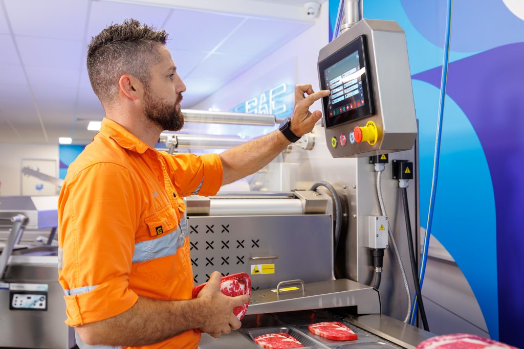 A VACPAC technician testing a vacuum packaging machine. 